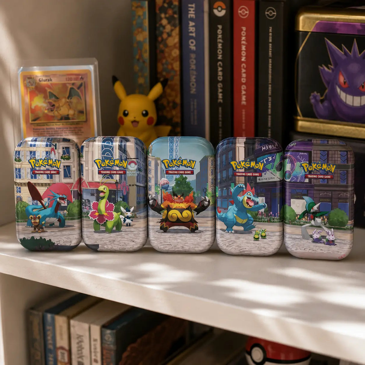 Pokemon Lumiose City Mini Tins – alle 5 Designs auf Sammler-Regal, mit Pikachu-Figur und Charizard-Karte
