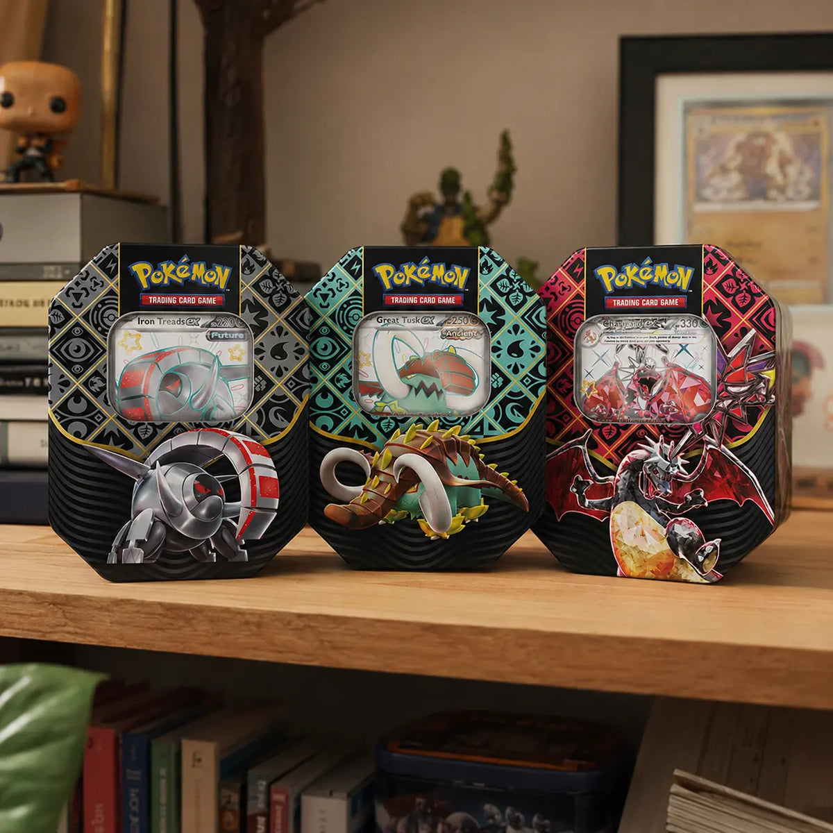 Pokemon Paldean Fates Tin auf Holzregal – Alle drei Varianten aufgereiht mit Funko Pop und Buecher im Hintergrund