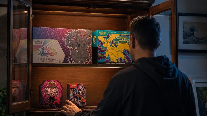 Pokemon Sealed Collection bestehend aus mehreren Produkten, wie Ascended Heroes Elite Trainer Box, Rocket Tin und Destined Rivals Booster Bundle. Alles zusammengestellt und präsentiert in einer Vitrine.