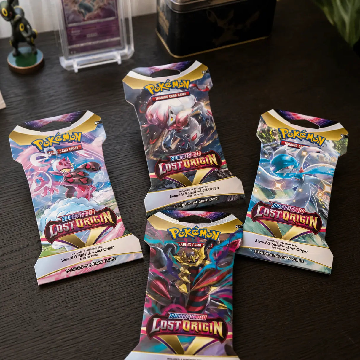 Pokemon Lost Origin Sleeved Booster – vier Packs auf Holztisch, sammlersicher verpackt von CardsRfun