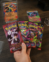 Pokemon Mega Charizard Tin – Hand hält 4 Booster Packs, Mega Charizard X ex und Y ex Promos im Hintergrund