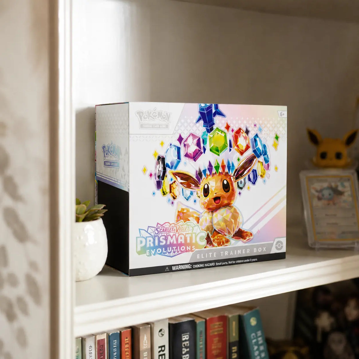Pokemon Prismatic Evolutions Elite Trainer Box im Regal – Lifestyle mit Eevee Funko Pop und gegradetem Vaporeon